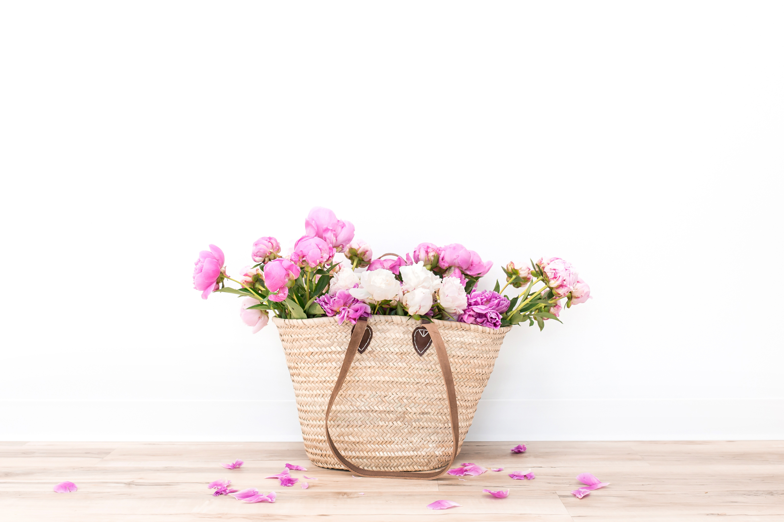 woven tote with peonies spilling out the top