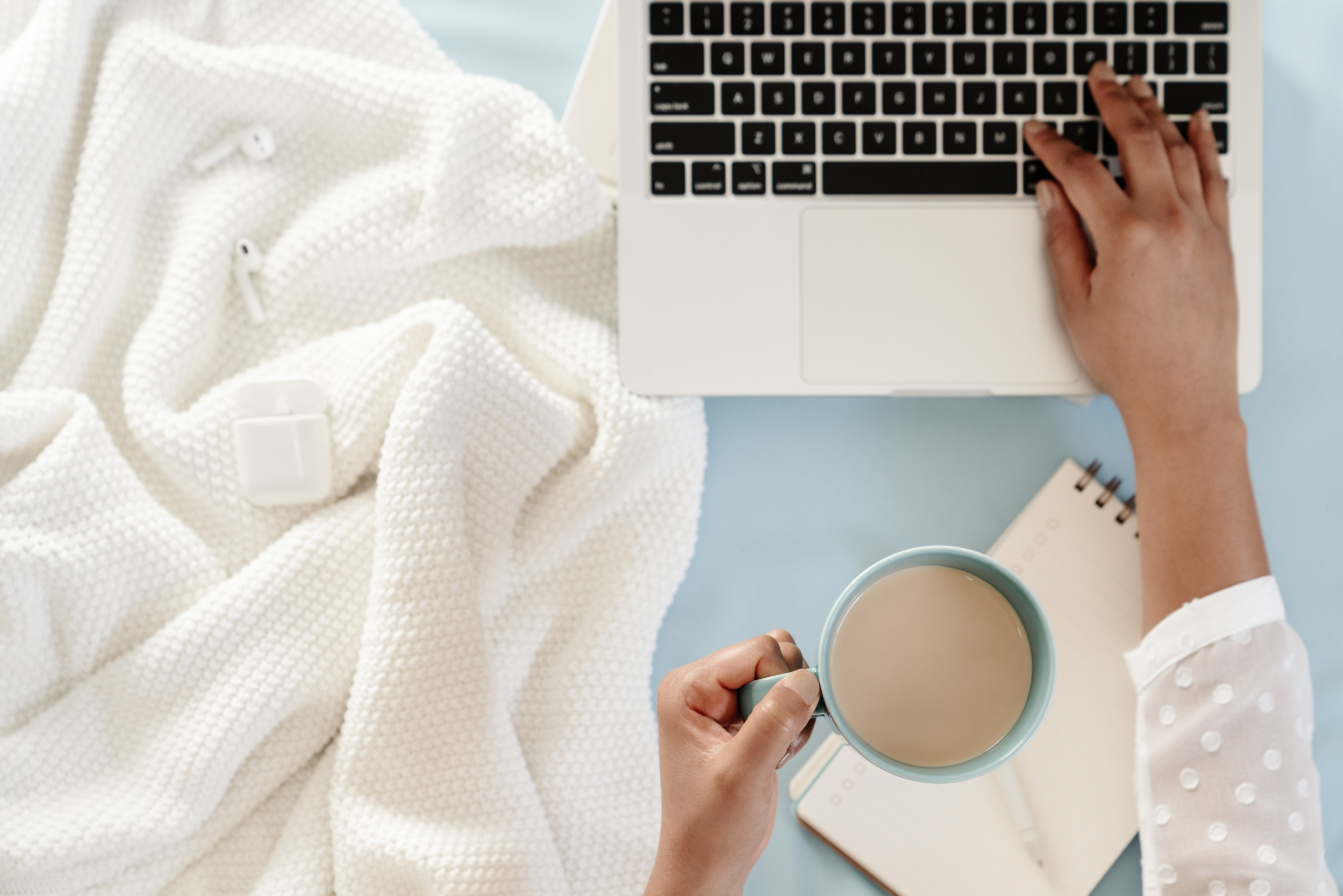 laptop computer and hands with cup of coffee